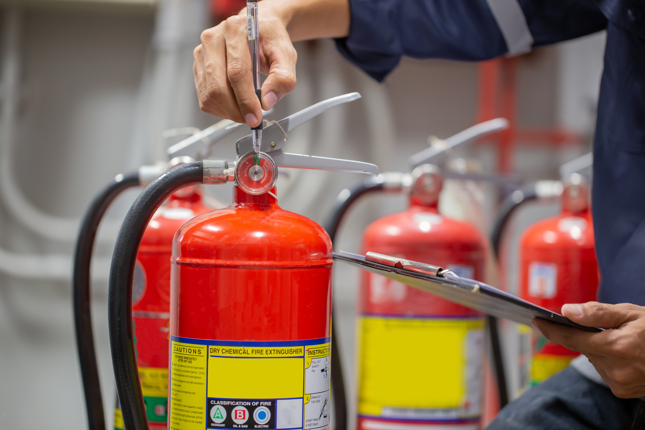 Engineer are checking and inspection a fire extinguishers tank in the fire control room for safety training and fire prevention.