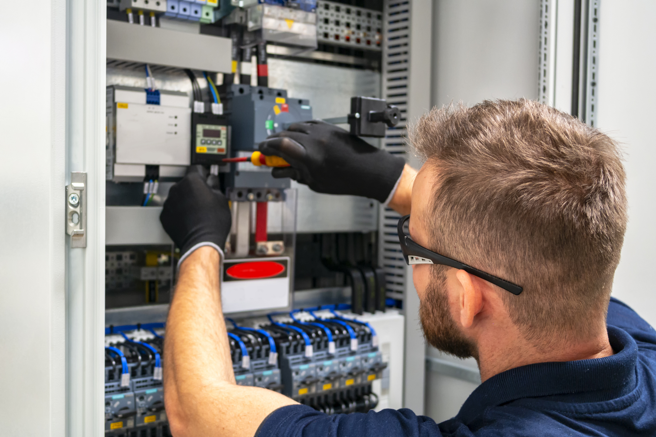 Photo of an electrician working at distribution board.