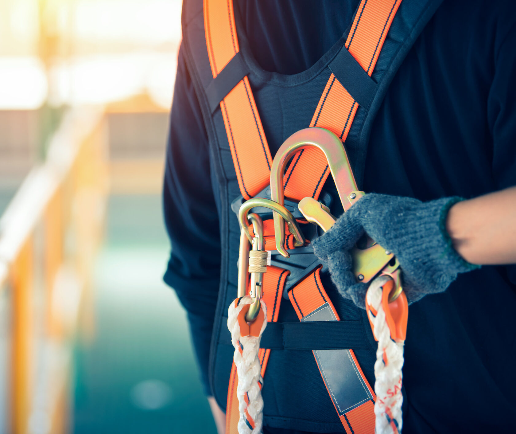 Construction worker wearing safety harness and safety line working at high place